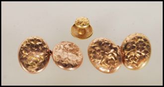 A pair of hallmarked 9ct gold cufflinks of oval form having floral engraving together with a