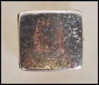 A silver hallmarked cigarette case of shaped bowed rectangular form having engraved foliate design