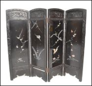 A early 20th Century Chinese four-fold screen having carved foliate borders. Inserted black