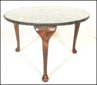 A 20th Century vintage glass topped coffee table of round form being set with an array of exotic