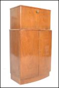 A mid century, post war Art Deco style walnut cocktail / drinks cabinet. Of bow front form raised on