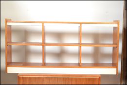 A retro 20th Century teak wood low open bookcase together with another of sectional form.