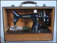 A vintage mid 20th Century cased Singer manual sewing machine set within a faux crocodile carry