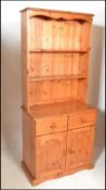 A 20th Century antique style pine Welsh dresser. The dresser having an open shelved upright
