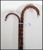 Two early 20th Century walking stick canes having crook handles with silver tips. One being bamboo