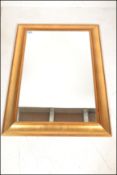 A 20th century Antique style revival gilt mirror of rectangular form with cushion frame having