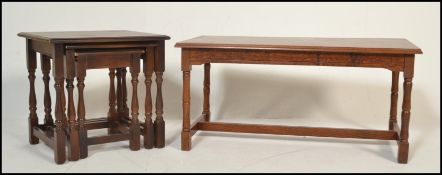 A mid 20th Century nest of three graduating tables raised on turned block legs together with a