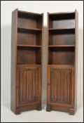 A pair of early 20th century / 1930's oak upright pedestal bookcase cabinets. Each on plinth bases