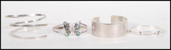 A group of four stamped 925 silver bangle bracelets to include a butterfly bangle set with mother of