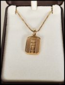 A 9ct gold box link necklace chain set with a gold hallmarked ingot pendant of oblong form having