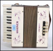 A vintage German Hohner Student accordion with cream veneer. Complete with leather straps. In