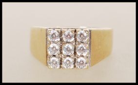 A hallmarked 375 9ct gold ring, prong set with nine white stones in square formation on a tapering