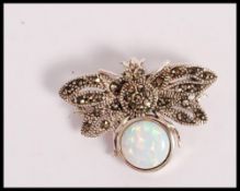 A stamped 925 silver bug brooch being set with a round opal panel and marcasites. Weight 6.2g.