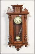 A 20th Century Vienna walnut cased regulator wall clock having a carved scallop shell pediment to