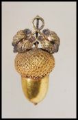 An unmarked Victorian gold pendant in the form of an acorn having a bale to the top with a twin leaf