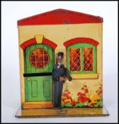 A early 20th Century 1920's / 30's advertising tin money box bank in the form of a house having a