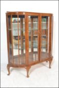 An early 20th Century / 1940's Queen anne revival walnut bow front glazed display cabinet having a
