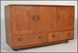A stunning mid 20th Century Ercol beech and elm Windsor pattern sideboard credenza, three cupboard