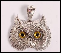 A stamped 925 silver pendant / brooch in the form of an owl set with yellow and black gallas eyes.