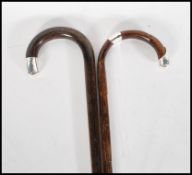 Two early 20th Century walking stick canes having crook handles with silver tips. One being bamboo