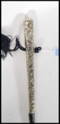 A 20th Century walking stick cane of tapering form having silver white metal embossed foliate