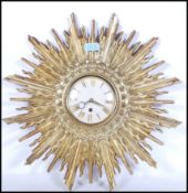 A vintage 20th Century Art Deco style sunburst starburst rising sun wall clock having a gilt