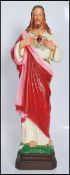 A 20th Century cast resin hand painted figurine in the form of Jesus Christ having a sacred heart to