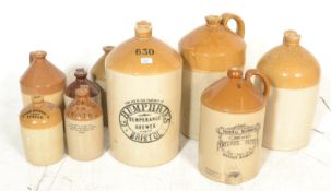 A collection of vintage local interest stoneware advertising flagons of varying sizes to include
