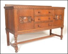 An early/ mid 20th Century oak sideboard having a central bank of three drawers with turned knob