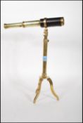 A vintage 20th Century brass table / desk top telescope being leather bound and raised on a brass