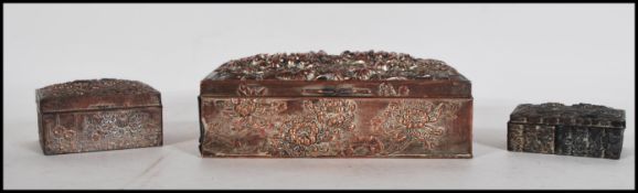 A group of three 20th Century graduating Chinese desk top boxes having repousse decoration of
