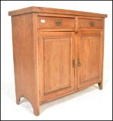 An early 20th Century Edwardian oak sideboard having twin cupboard doors with two drawers above,