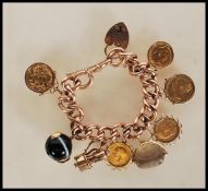 A stamped 9ct gold curb link charm bracelet having a heart padlock clasp, charms include three