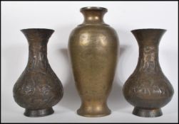 A pair of 20th Century Indian brass vases having embossed relief decorated scenes of a shepherd
