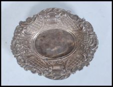 A 20th Century silver hallmarked pin dish of oval form having swirl and foliate embossed relief