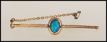 A 9ct gold and black opal doublet ladies bar brooch. The brooch with twin bar, central cabochon opal