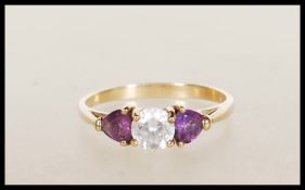 A stamped 375 9ct gold ladies dress ring set with a round cut CZ flanked with two heart cut purple