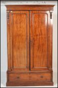 A Victorian mahogany double wardrobe armoire being raised on a plinth base having single drawer with