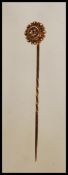 A 15ct gold Victorian stick pin, the head with roundel form having filigree work surrounding a