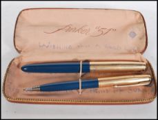 A Parker '51' pen and mechanical pencil having blue shafts with gold plated lids, within a fitted