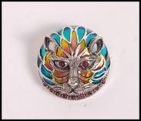 A stamped 925 silver plique a jour brooch in the form of a cat set with marcasites and red stones.