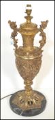 A large 20th Century twin handled gilt metal table lamp of urn shape form having pictorial relief
