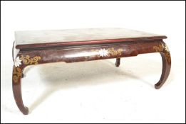 A 20th Century Chinese lacquered burgundy opium table / coffee table raised on bowed legs with