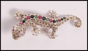A stamped 925 silver brooch in the form of a lizard set with cz's, rubies, sapphires and emeralds.