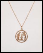 A stamped 9ct gold necklace having a round pendant having pierced decoration in the form of a dog,