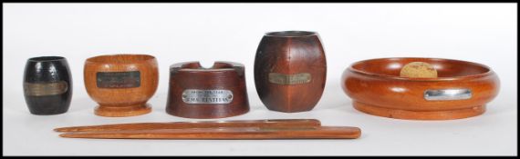 A group of five ashtrays of various forms being made from the teak of multiple boats, each one