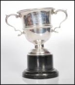WITHDRAWN-  A hallmarked silver early 20th century twin handled trophy cup raised on stepped