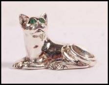 A sterling silver figurine in the form of a cat set with emerald eyes. Weight 10.6g. Measures 2cm