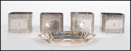 A set for Elkington silver plate napkin rings of square octagonal form having engraved foliate and