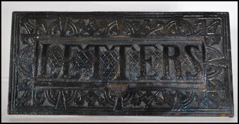 An early 20th Century Edwardian cast metal letter box, the frame of the letter box cast in relief